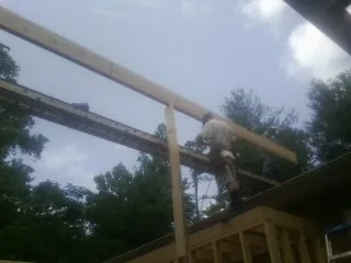 Carpenter setting a ridge beam over a new addition frame — Ice Dam Removal by Roofing Brothers in Thayne