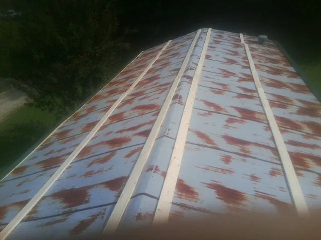 Rusted metal roof panels with new wood purlins before replacement — Storm Damage Roof Repair in Thayne by Roofing Brothers