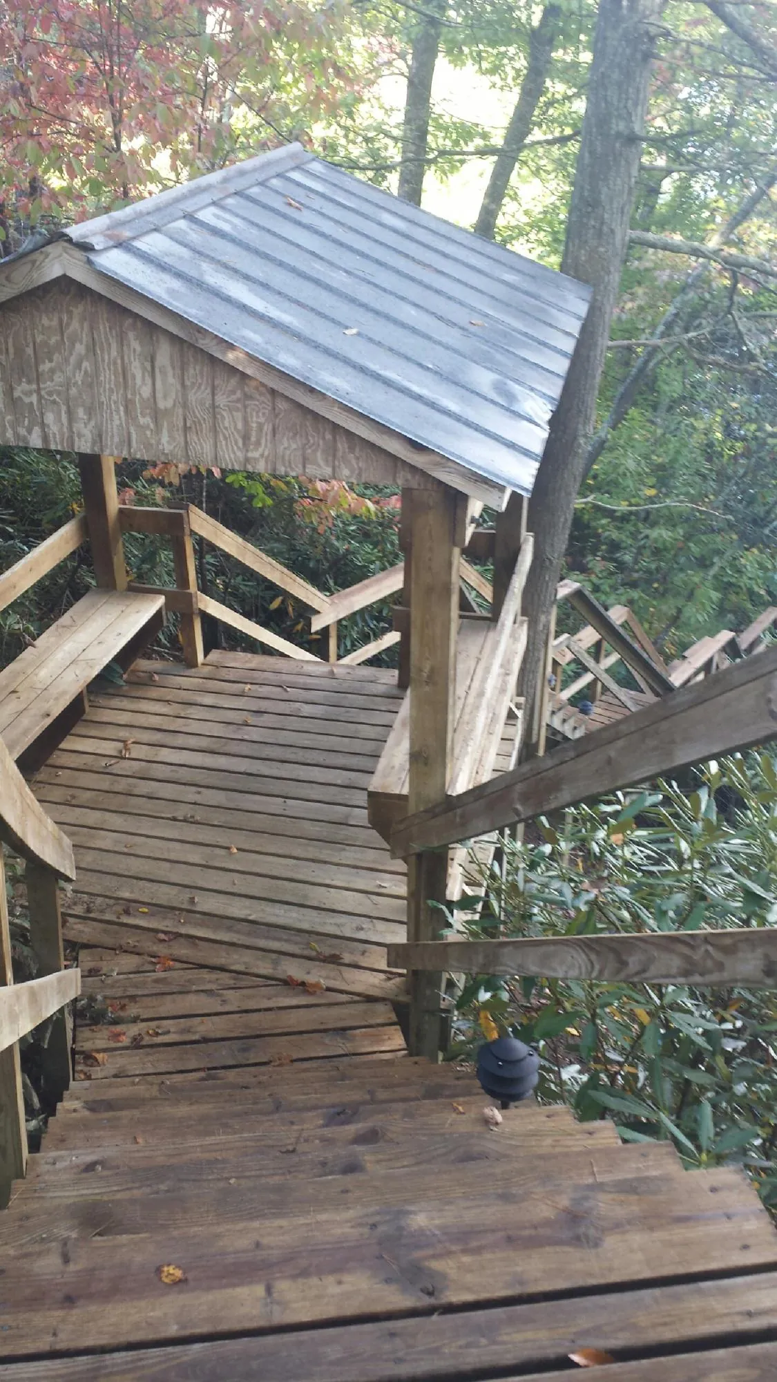 Metal roofed shelter over wooden steps on a wooded walkway — Skylight Repair & Installation work by our crew in Thayne