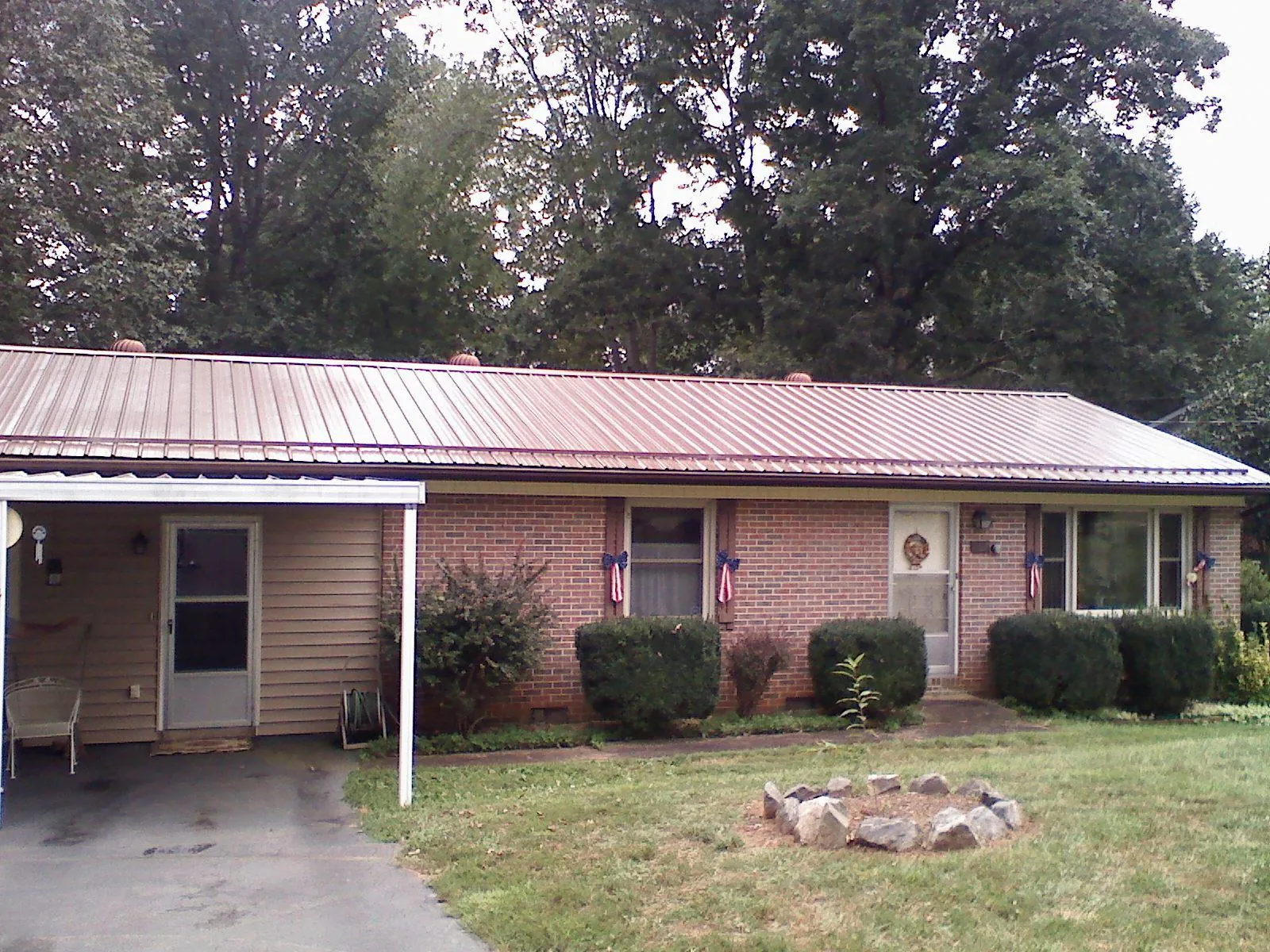 Bronze metal roof and carport on a brick ranch home — Roof Repair work by our crew in Thayne