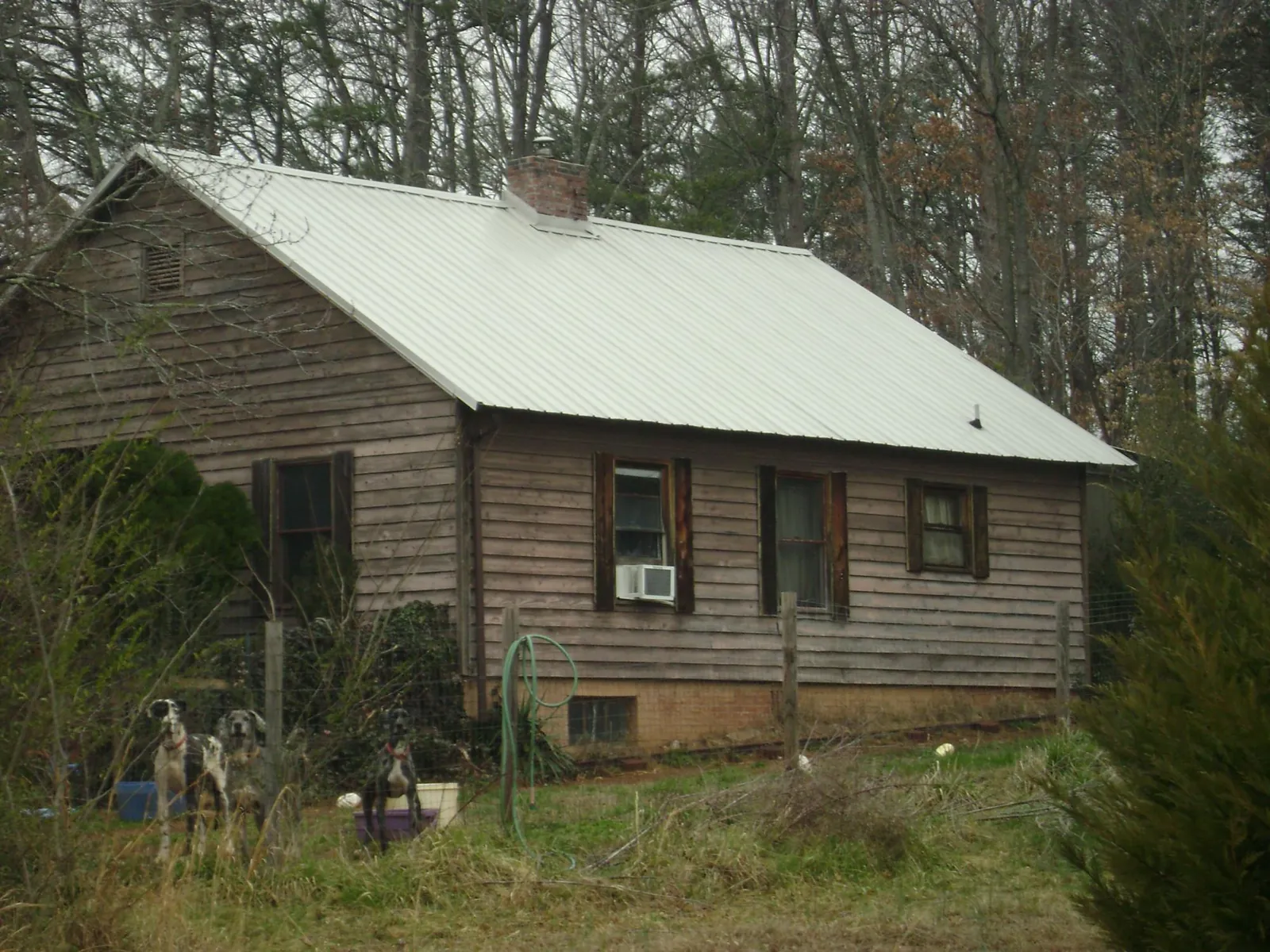 White metal roof on an old wood sided farmhouse, from a Metal Roof Installation job in Thayne